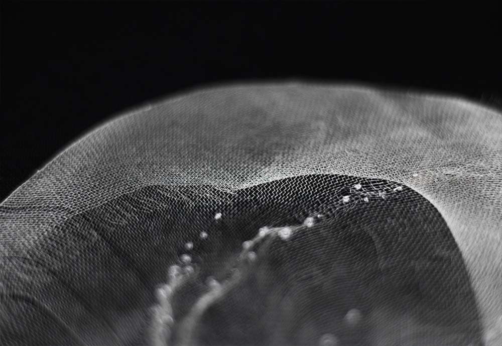 a closeup to silk mesh embroidered with tiny knots