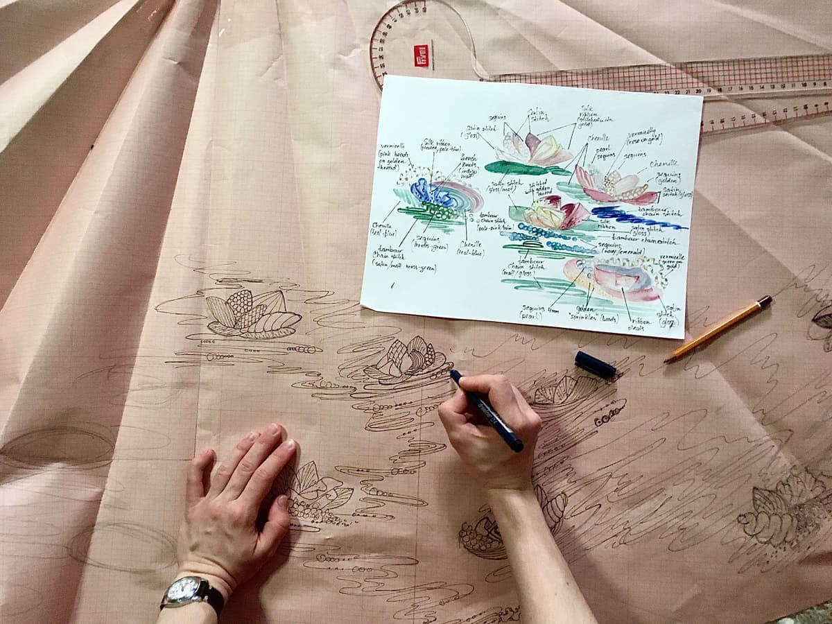 the hands drawing the embroidery design