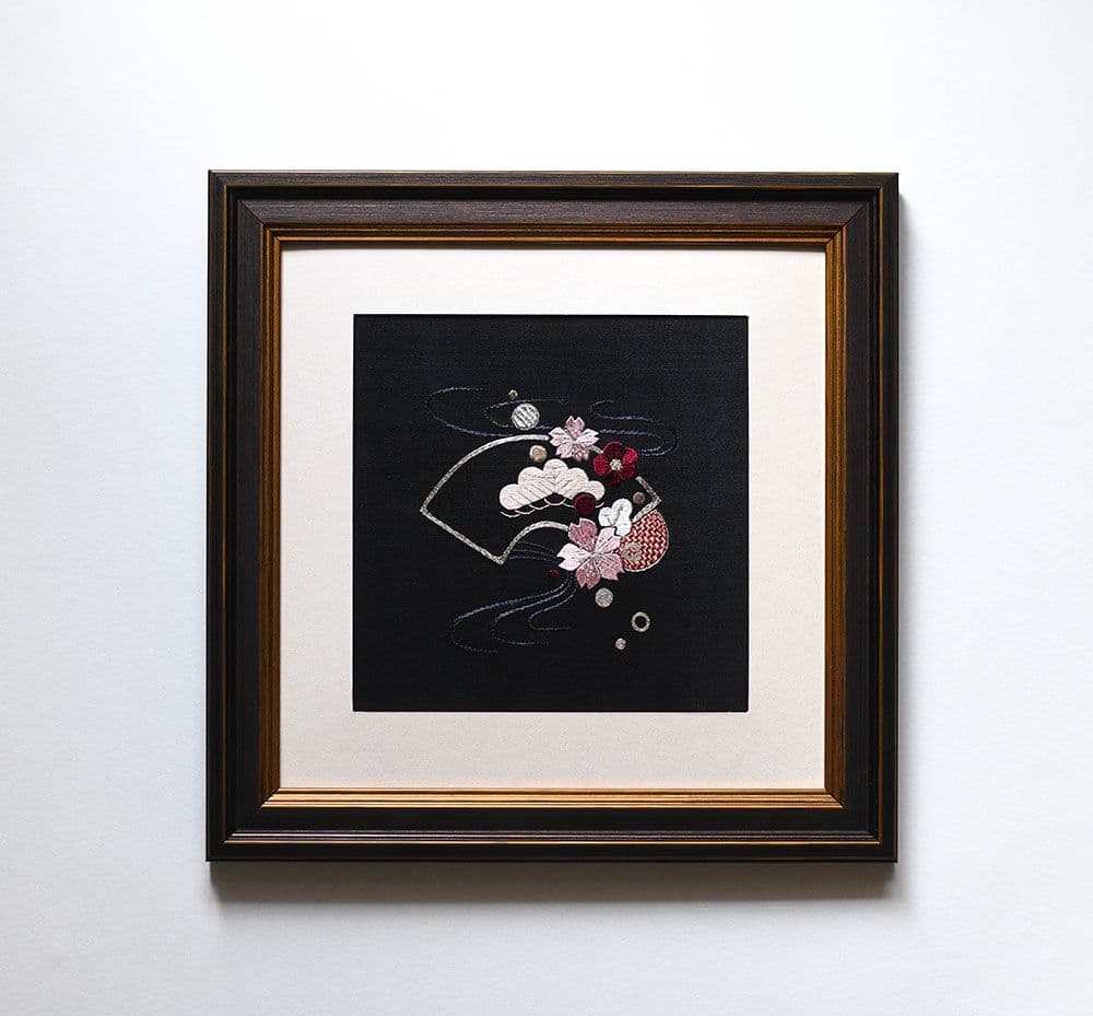 a framed piece of silk embroidery