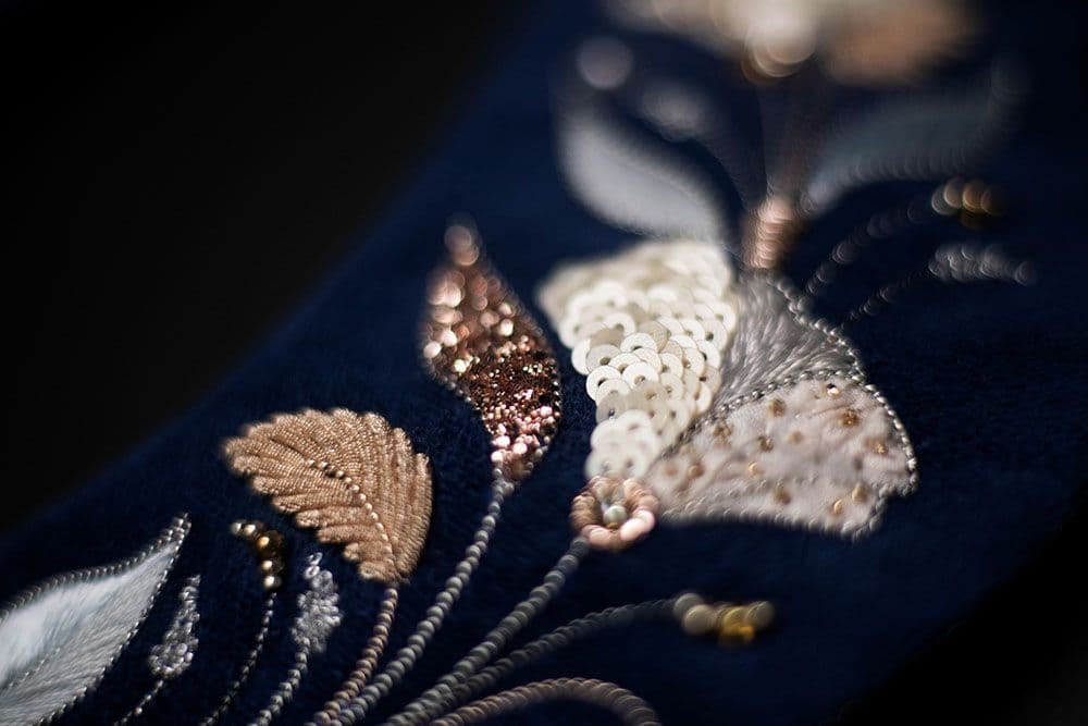 a close-up to the piece of the embroidery with carnation flower