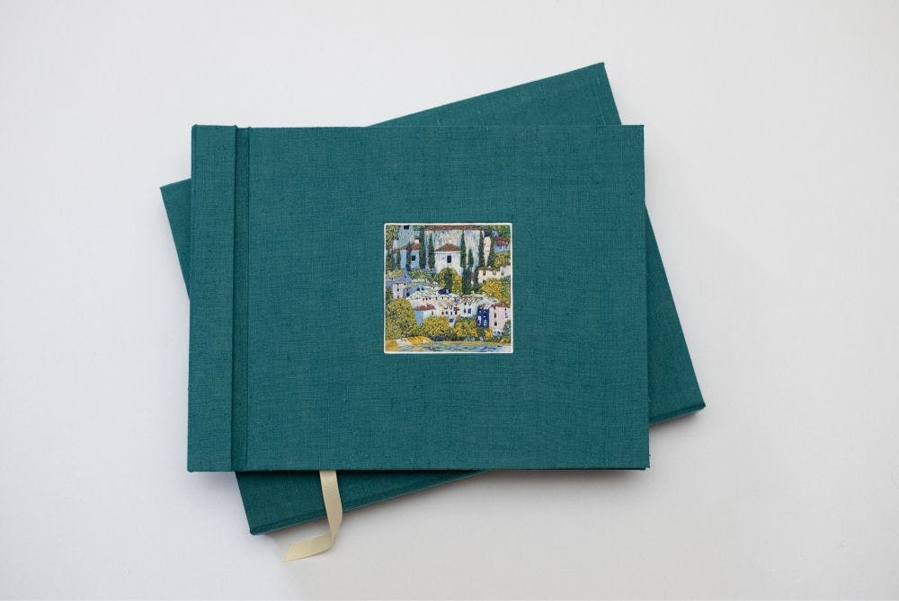 a hand-made photo album decorated with an embroidered picture inspired by Gustav's Klimt painting “Church in Cassone”