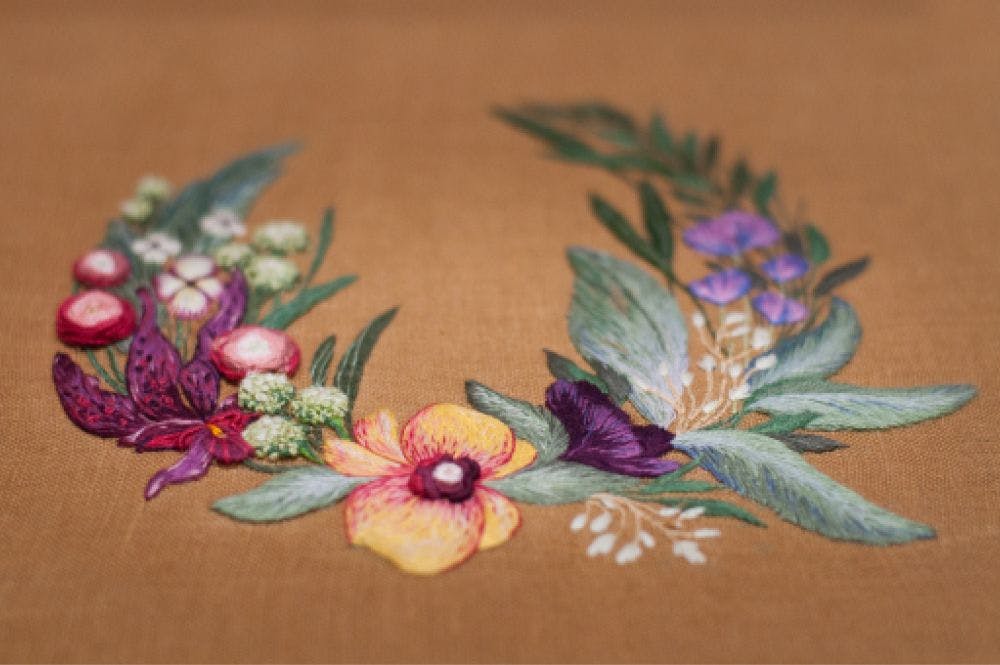 a close-up of a hand-made photo album decorated with an embroidered design of exotic flowers blossoming