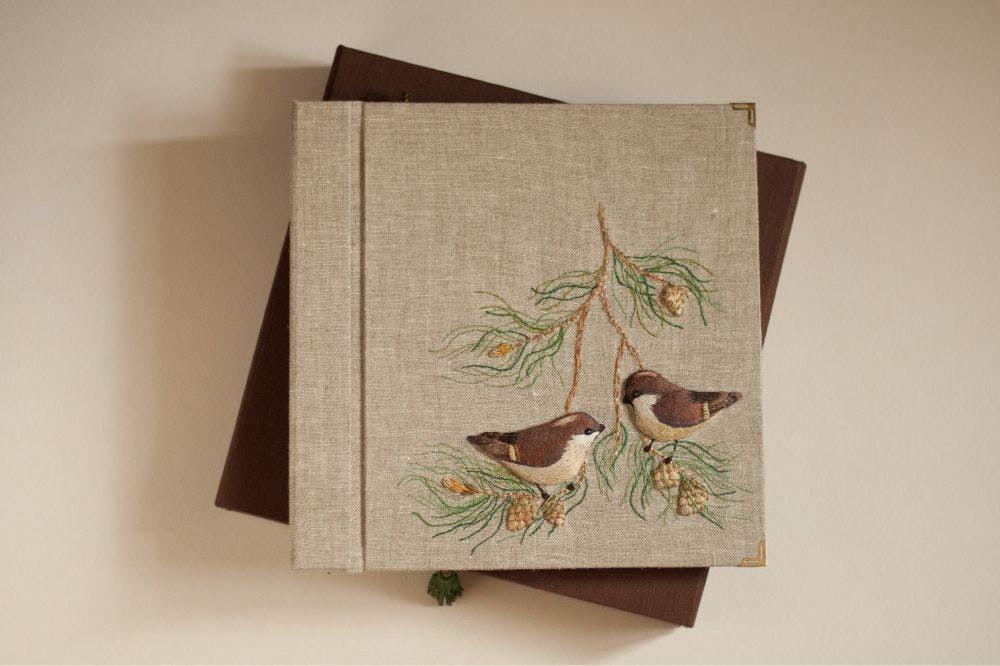 the cover of a hand-made photo album decorated with stumpwork embroidery
