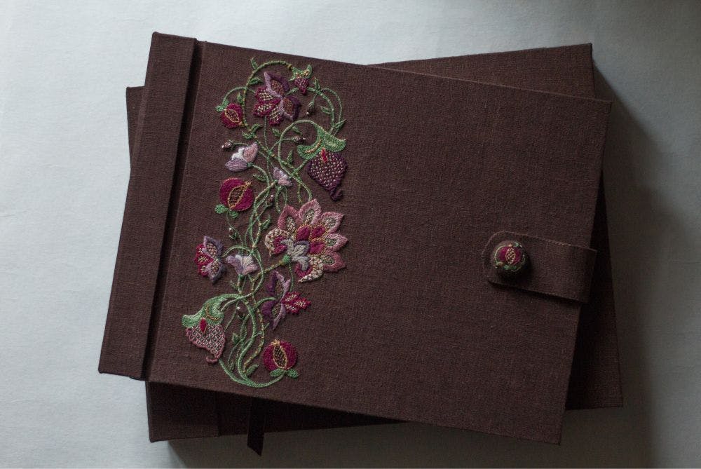 the cover of of a hand-made photo album decorated with Jacobean embroidery motifs