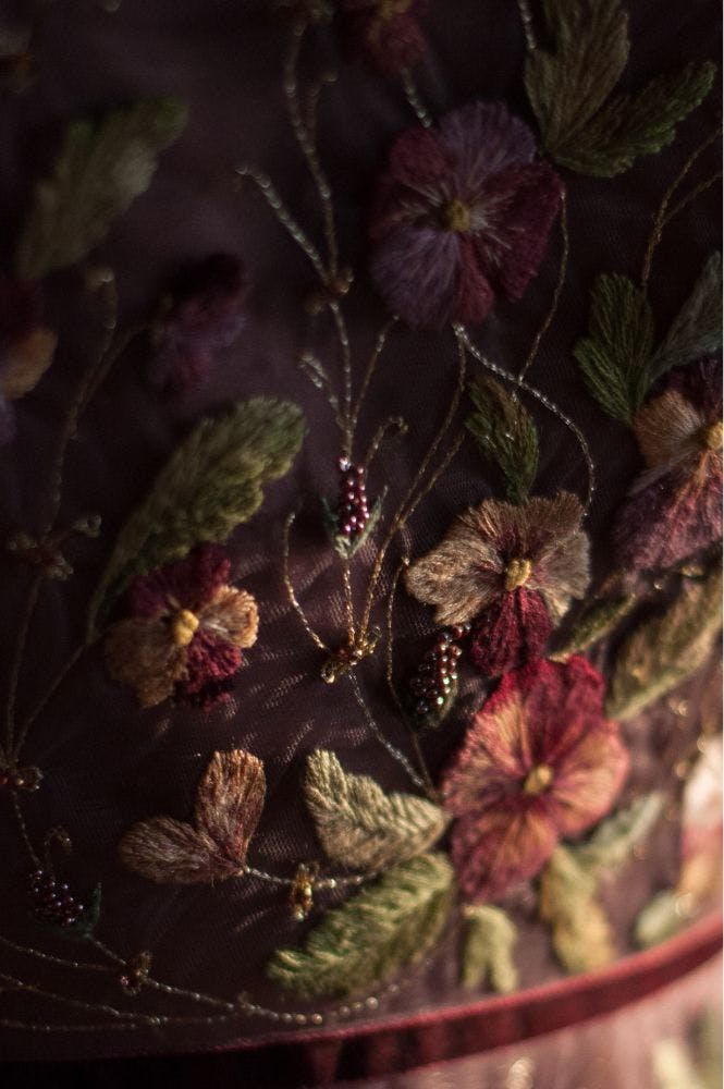 close up of an embroidered dress with violets