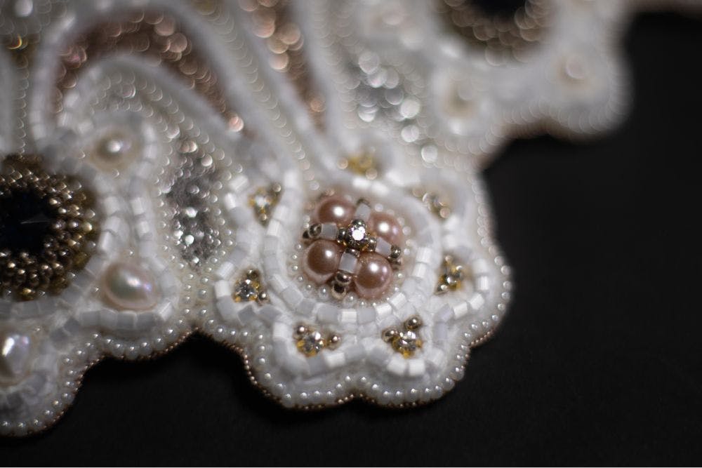the close-up of the beaded element of the embroidery