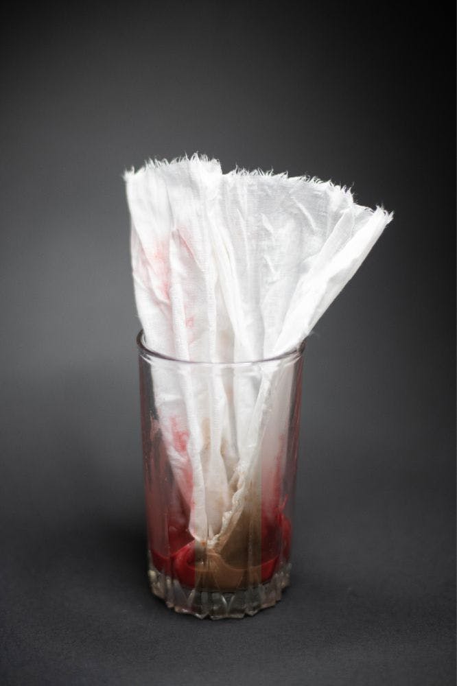 a glass with red organic dye and a pice of cloth