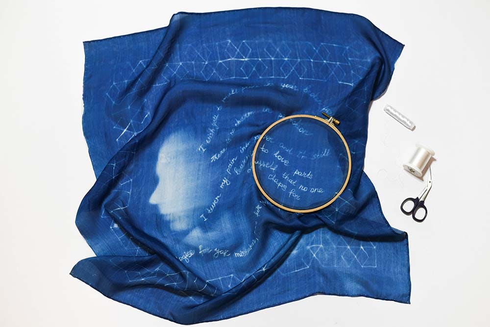 a captured process of hand-stitching of cyanotype scarf