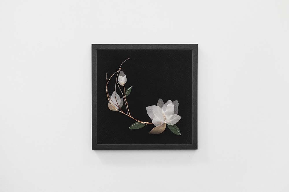 a framed work with magnolia textile composition