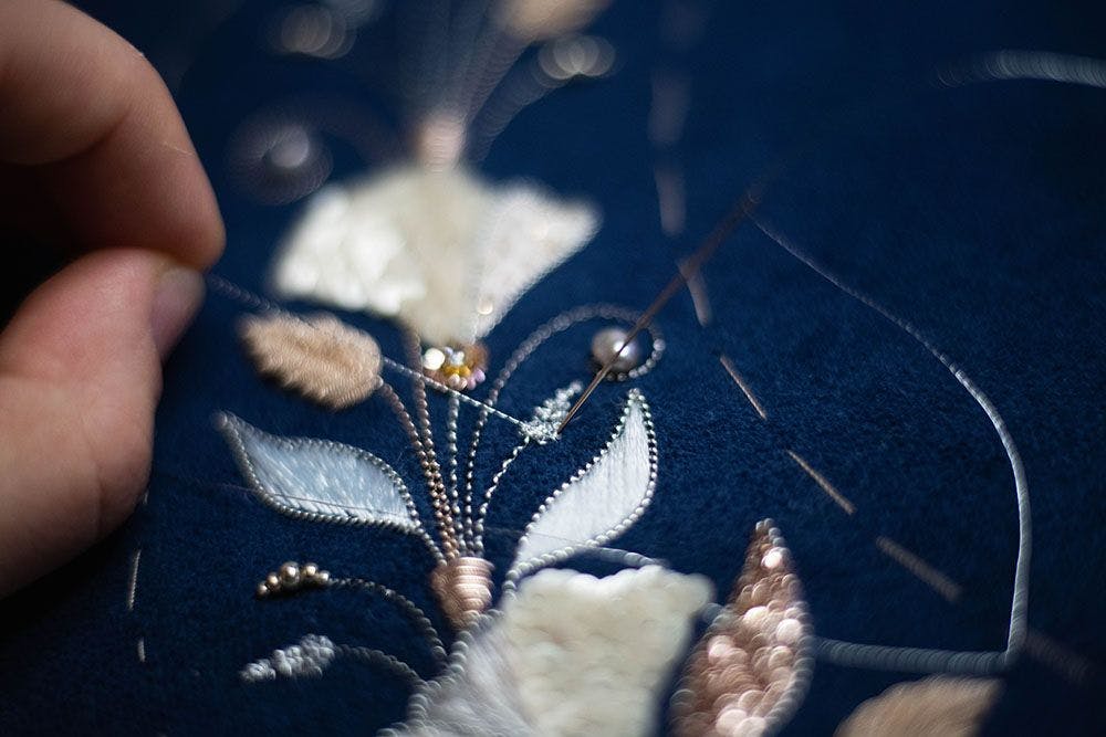 a close-up to the embroidered leaves framed in silver purl